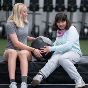 Adaptive fitness athlete performing functional strength exercises with a medicine ball